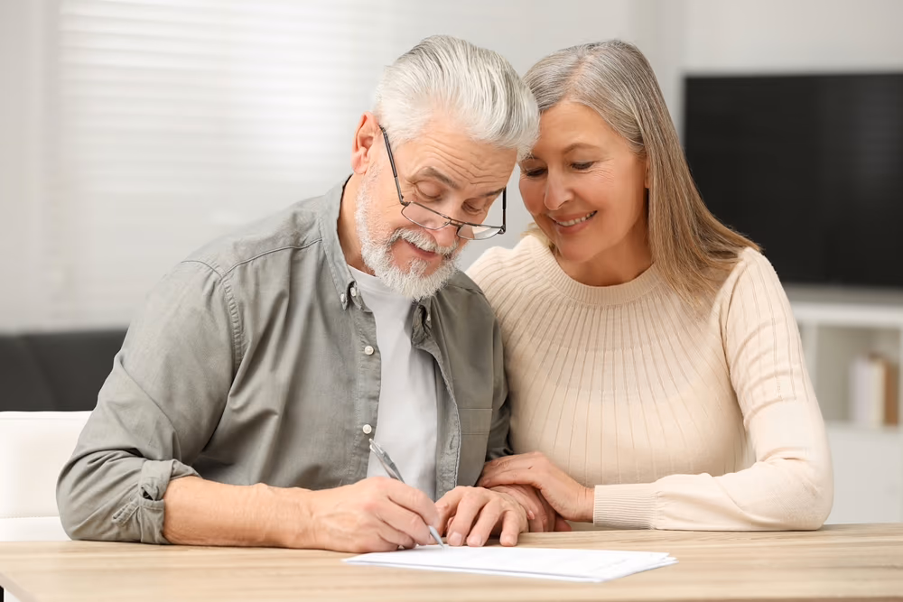Senior couple signing their last will and testament indoors